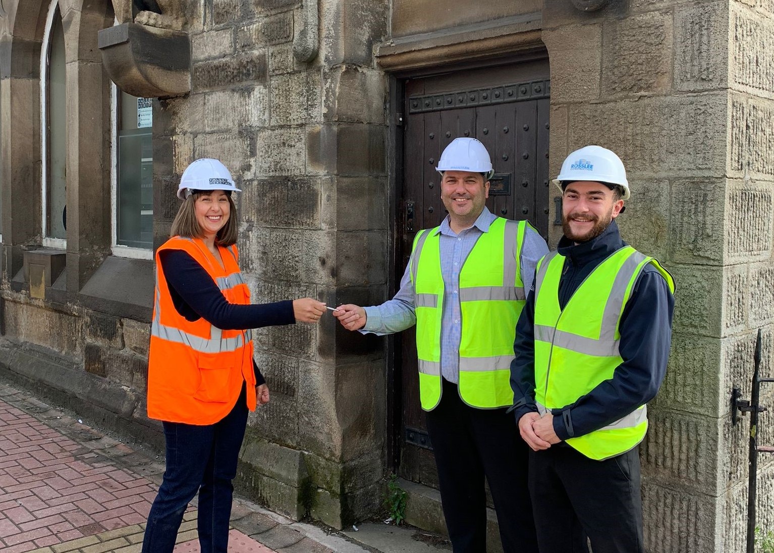 Valley Heritage hand over the keys to Rosslee Construction outside the front door of Alliance at the Lancashire and Yorkshire Bank